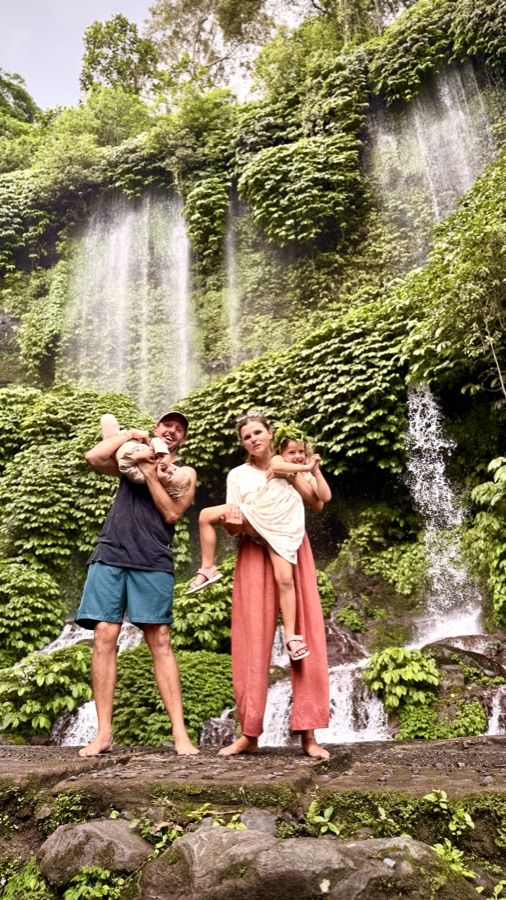 Familie vor einem Wasserfall im Dschungel